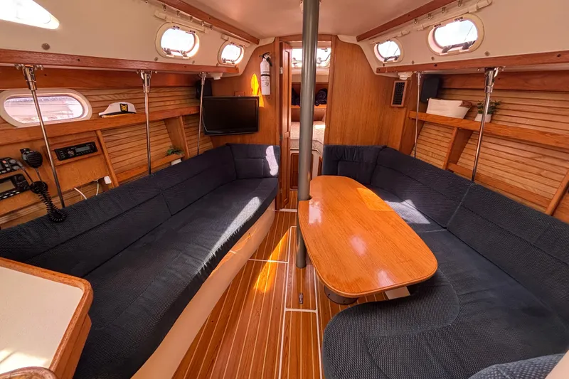Slide: The Image of Interior of 2006 Catalina 320 sailboat with cozy seating and wooden table. - 21