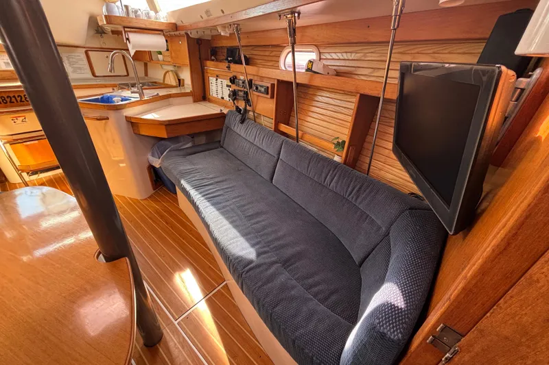 Slide: The Image of Interior of 2006 Catalina 320 sailboat with cozy seating and wooden finishes. - 22