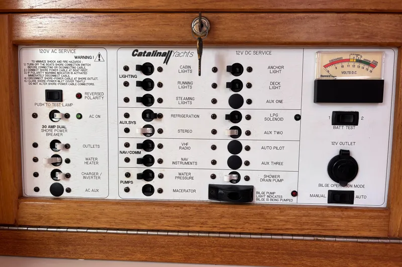 Slide: The Image of Catalina 320 2006 electrical panel with switches and gauges for boat systems. - 24