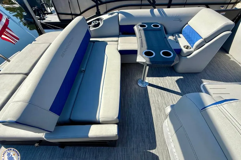 Slide: The Image of 2021 Bennington 22 LSB pontoon boat interior with seating and table, featuring cup holders. - 10