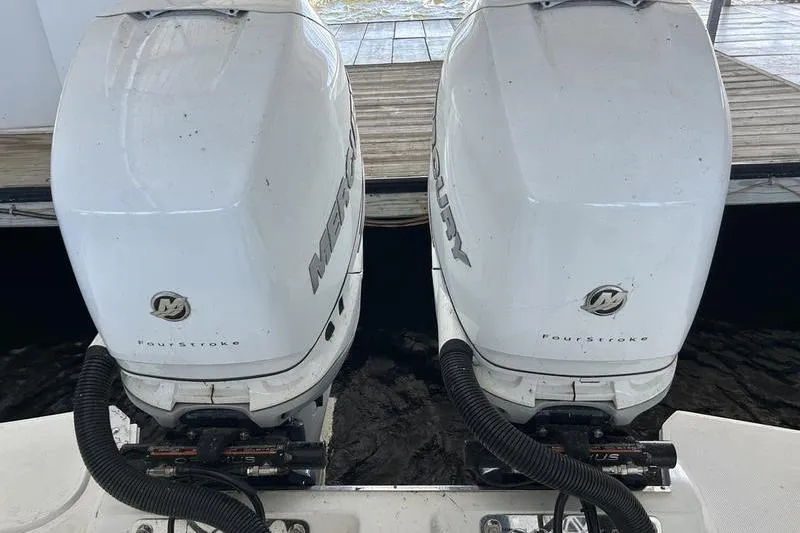 Slide: The Image of Twin Mercury outboard engines on a 2022 Cobalt 30SC boat, docked by wooden pier. - 10