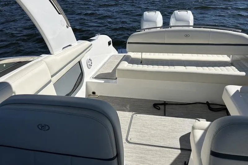 Slide: The Image of 2022 Cobalt 30SC Outboard boat interior with white seating and ocean backdrop. - 4