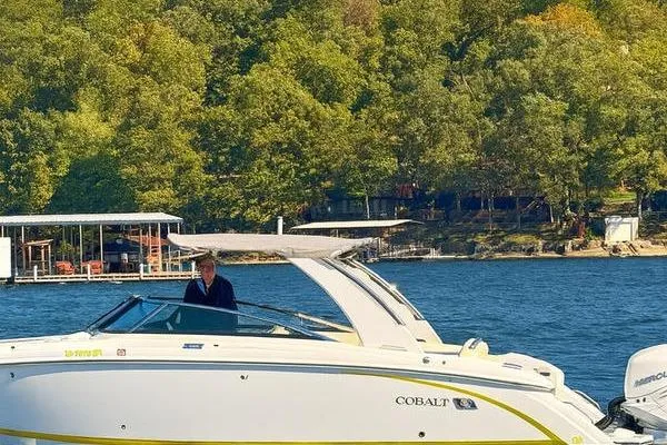 Slide: The Image of 2022 Cobalt 30SC Outboard boat on a scenic lake with lush green trees. - 6