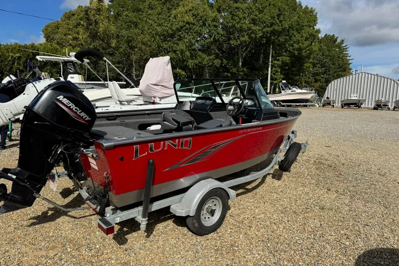 The Image of Red 2020 Lund 1675 Adventure Sport boat on trailer, parked outdoors. - 0