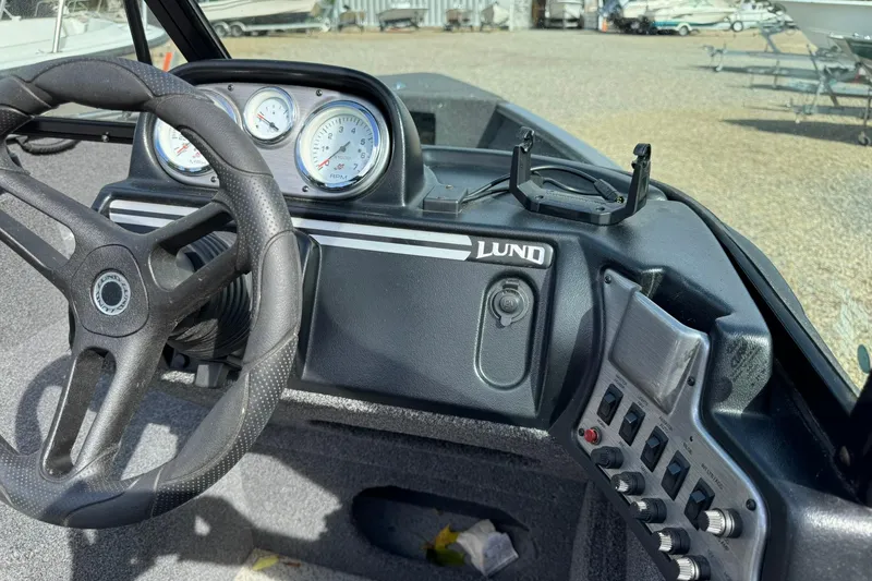 Slide: The Image of 2020 Lund 1675 Adventure Sport boat dashboard with steering wheel and gauges. - 10