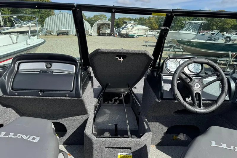 Slide: The Image of 2020 Lund 1675 Adventure Sport boat interior with steering wheel and storage compartment. - 14