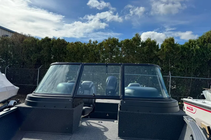 Slide: The Image of 2020 Lund 1675 Adventure Sport boat with windshield, parked outdoors under a blue sky. - 15