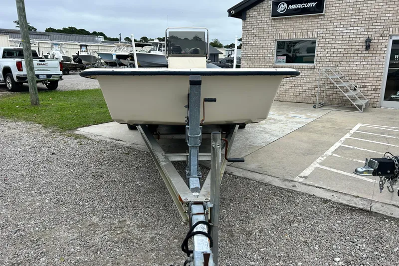 Slide: The Image of Front view of a 2000 Jones Brothers 22 Bateau boat on a trailer near a Mercury dealership. - 1