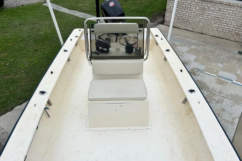 Slide: The Image of 2000 Jones Brothers 22 Bateau boat interior with console and seating, parked on concrete. - 10