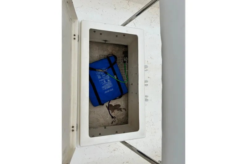 Slide: The Image of Storage compartment on a 2000 Jones Brothers 22 Bateau boat with a blue life jacket. - 25