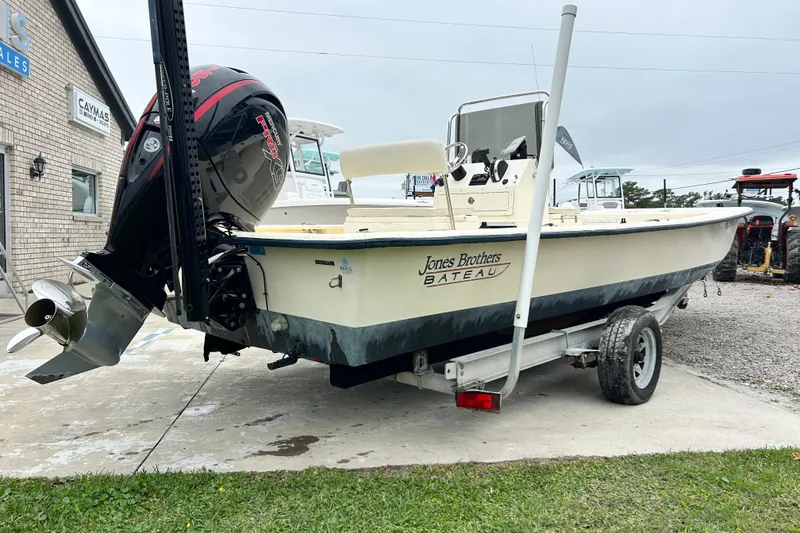 Slide: The Image of Jones Brothers 22 Bateau 2000 boat on trailer, parked near a building. - 6