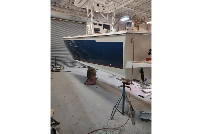 Slide: The Image of Custom Dominion 23 boat, 2023 model, on a trailer under a clear sky. - 10