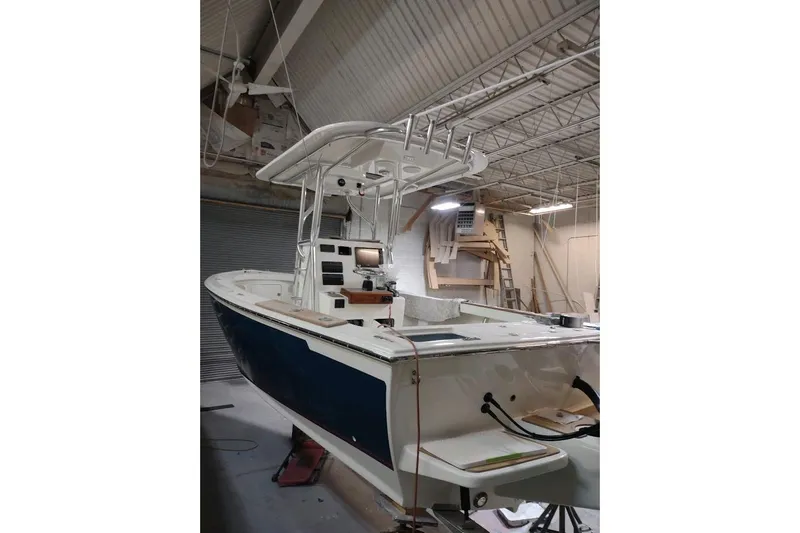 Slide: The Image of Custom Dominion 23 boat, 2023 model, in a workshop setting. - 12
