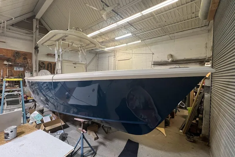 Slide: The Image of Custom Dominion 23 boat, 2023 model, in a workshop setting. - 13