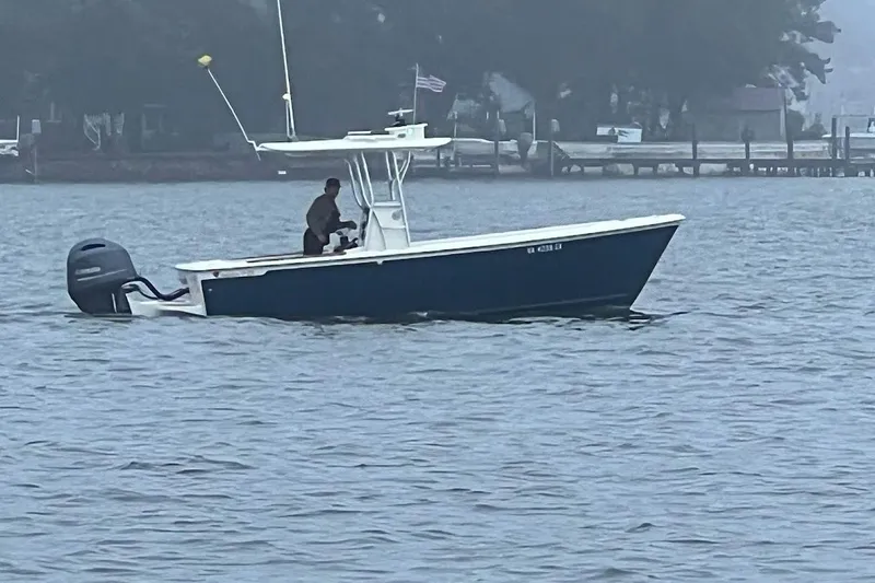 Slide: The Image of Interior view of 2023 Custom Dominion 23 boat at sunset on calm waters. - 2