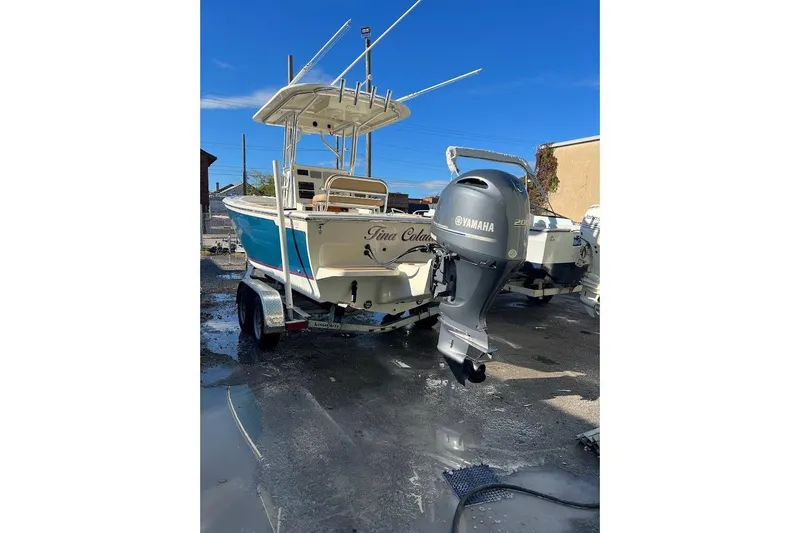 Slide: The Image of Person steering Custom Dominion 23 boat at sunset, 2023 model, with navigational screens. - 20