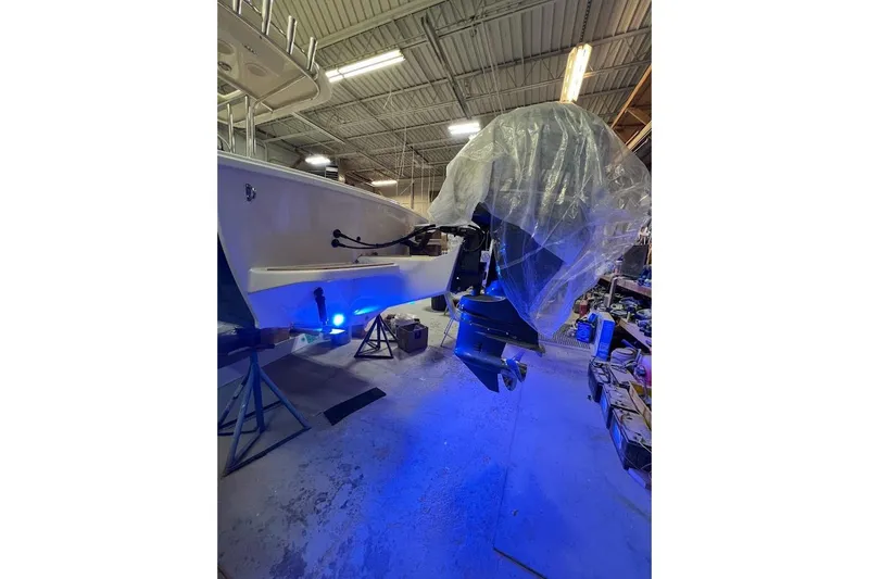 Slide: The Image of Custom Dominion 23 boat cruising, leaving a wake, with fishing rods and clear blue sky. - 22