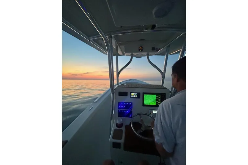 Slide: The Image of Custom Dominion 23 boat docked at marina, 2023 model, blue hull, calm water. - 24