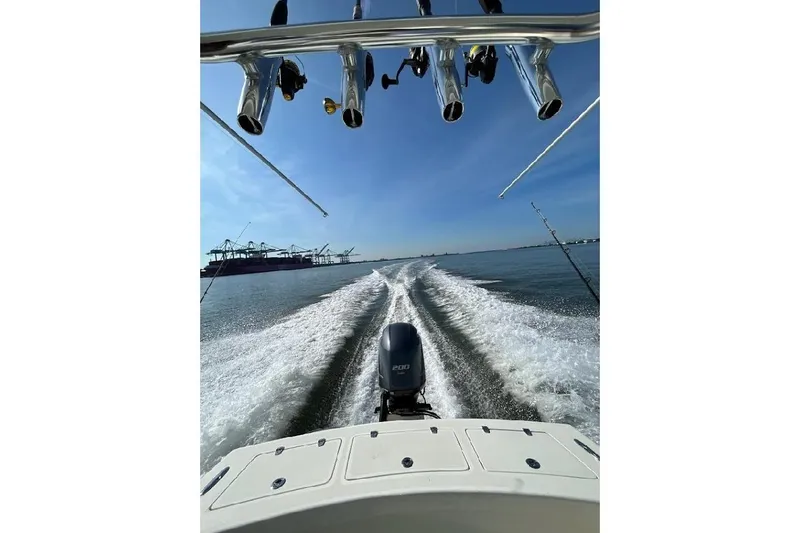 Slide: The Image of Custom Dominion 23 boat on trailer, 2023 model, parked outdoors under blue sky. - 26