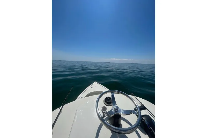 Slide: The Image of A 2023 Custom Dominion 23 boat docked near a pier with cranes in the background. - 27