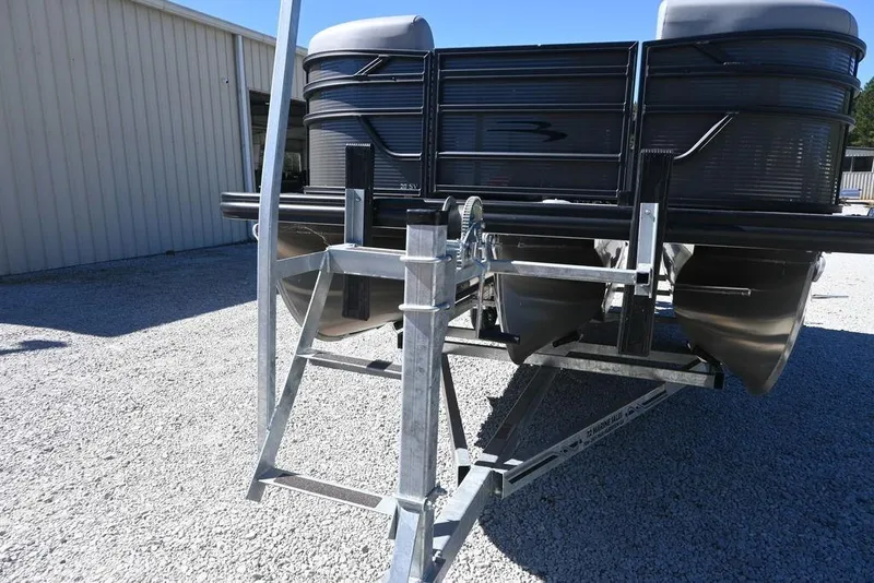 Slide: The Image of 2025 Bennington S 20 SSR pontoon boat on a trailer, parked on gravel. - 4