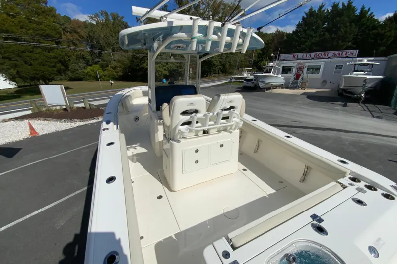 Slide: The Image of 2021 Cobia 280 Center Console boat at dealership, showcasing spacious deck and seating. - 11