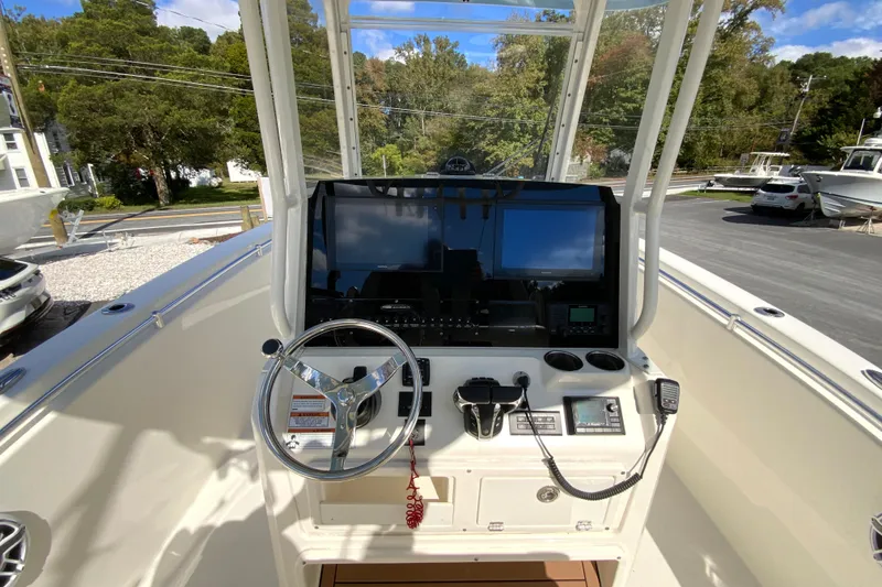 Slide: The Image of 2021 Cobia 280 Center Console boat dashboard with steering wheel and navigation controls. - 12