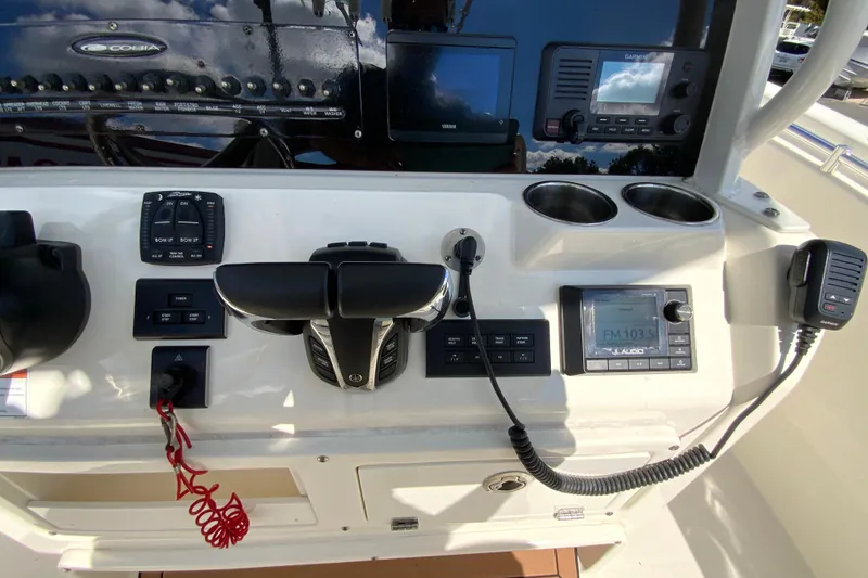 Slide: The Image of 2021 Cobia 280 Center Console dashboard with controls, radio, and cup holders. - 14