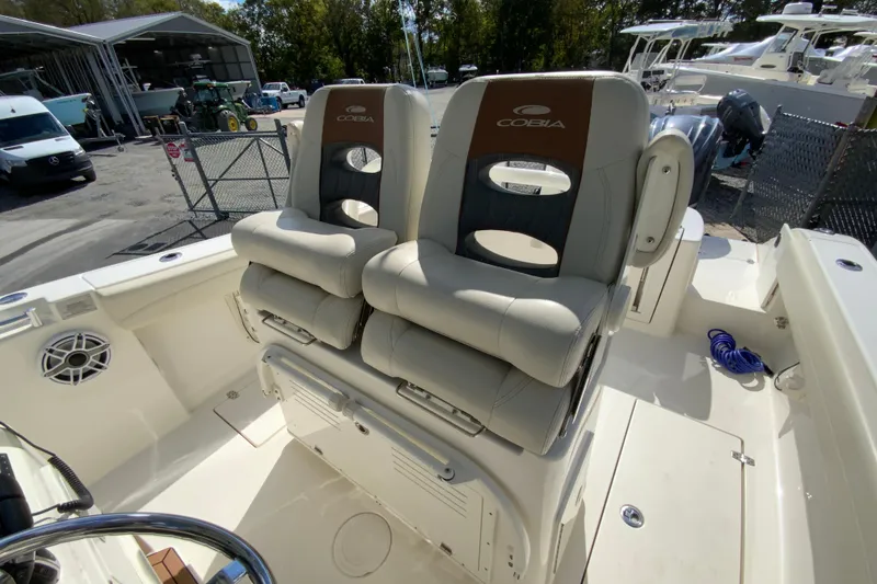 Slide: The Image of 2021 Cobia 280 Center Console boat with dual cushioned seats and storage area. - 15