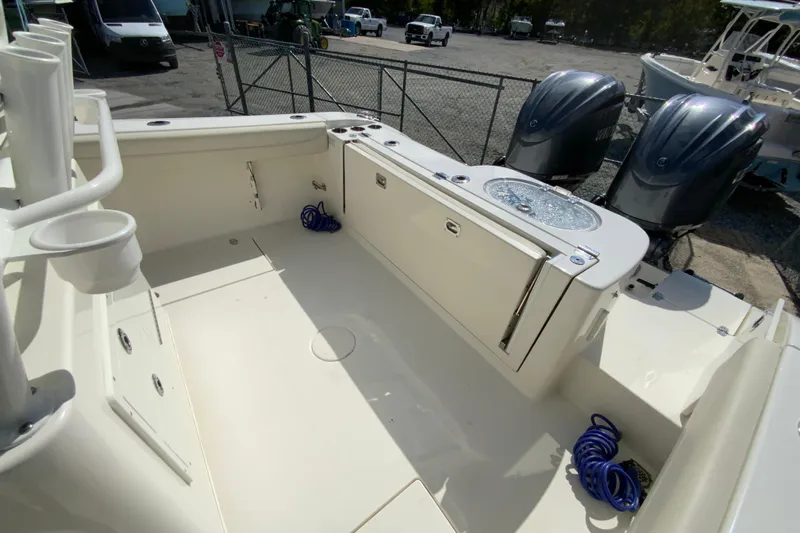 Slide: The Image of 2021 Cobia 280 Center Console boat deck with twin engines and storage compartments. - 17