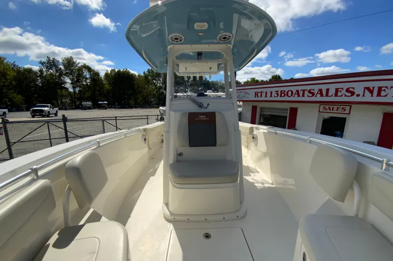 Slide: The Image of 2021 Cobia 280 Center Console boat interior with seating, under a blue sky. - 25