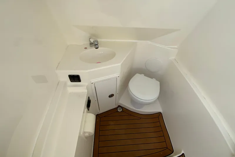 Slide: The Image of 2021 Cobia 280 Center Console boat bathroom with sink and toilet. - 28