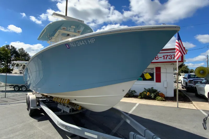 Slide: The Image of 2021 Cobia 280 Center Console boat on trailer, displayed outdoors under blue sky. - 3