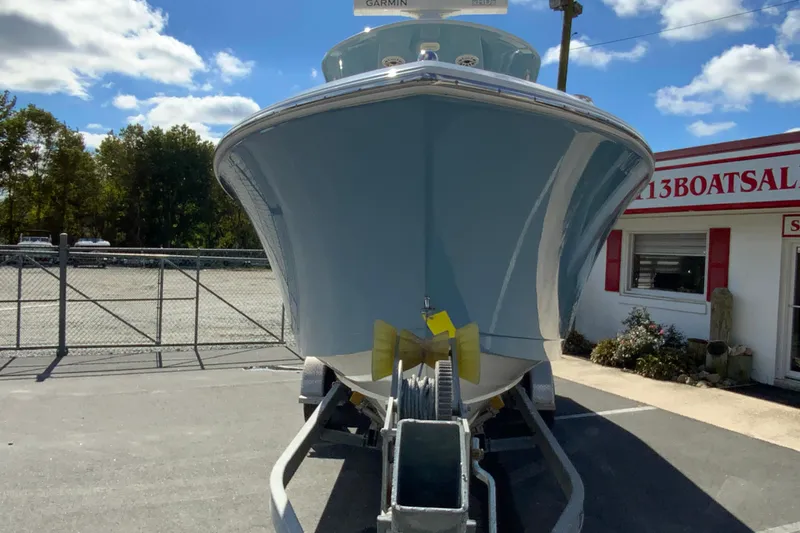 Slide: The Image of 2021 Cobia 280 Center Console boat on trailer at dealership under blue sky. - 4