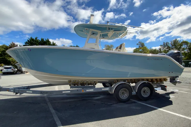 Slide: The Image of 2021 Cobia 280 Center Console boat on trailer under blue sky. - 6