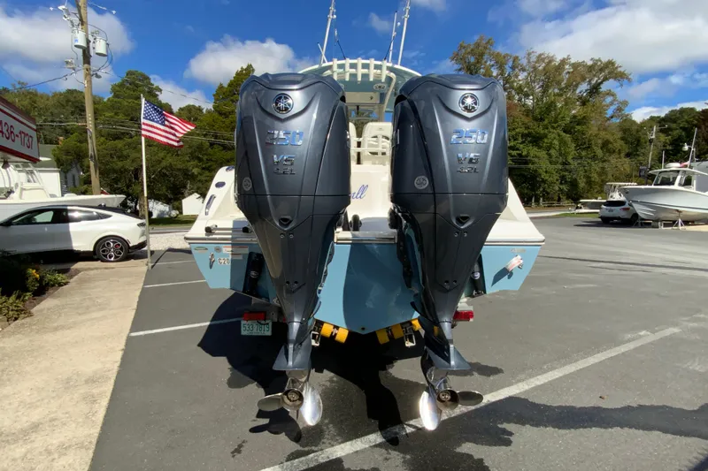 Slide: The Image of 2021 Cobia 280 Center Console with twin Yamaha outboard engines in a parking lot. - 9