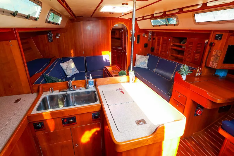 Slide: The Image of Interior of 2002 J Boats J/46 sailboat with wood finish and blue seating. - 17