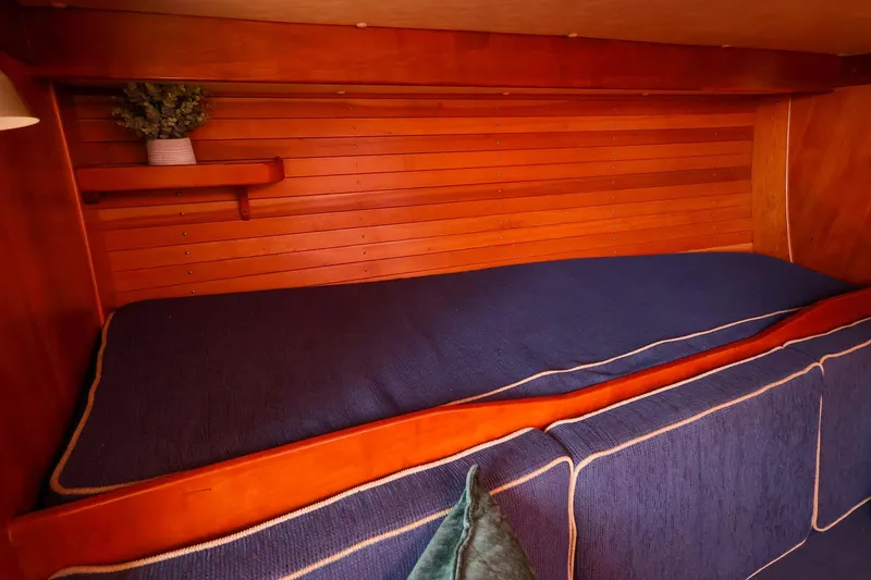 Slide: The Image of Cozy cabin interior of 2002 J Boats J/46 with wooden paneling and blue bedding. - 21