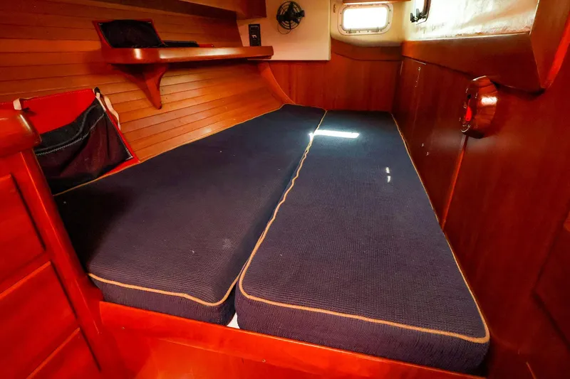 Slide: The Image of Interior cabin of 2002 J Boats J/46 with wooden paneling and blue cushions. - 28