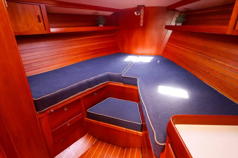 Slide: The Image of Cozy cabin interior of 2002 J Boats J/46 with wooden finish and blue cushions. - 29