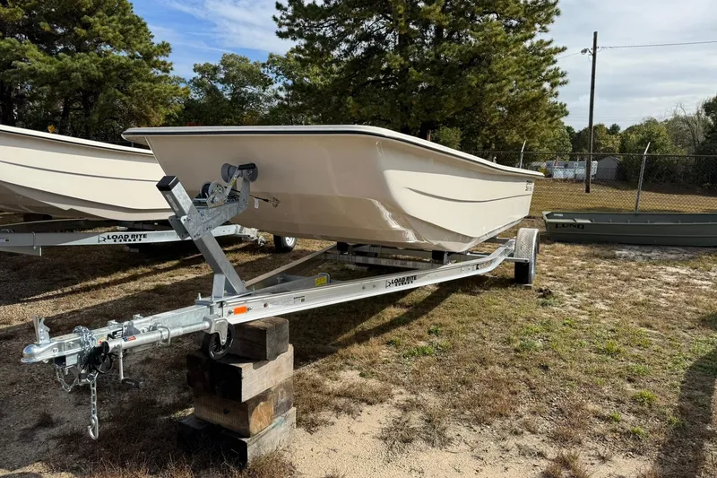 Slide: The Image of 2025 Carolina Skiff E21 DLX Kit boat on trailer, parked outdoors. - 6