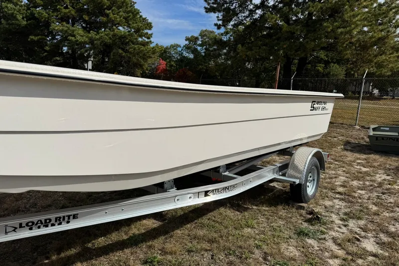 Slide: The Image of 2025 Carolina Skiff E21 DLX Kit boat on Load Rite trailer, outdoors. - 8