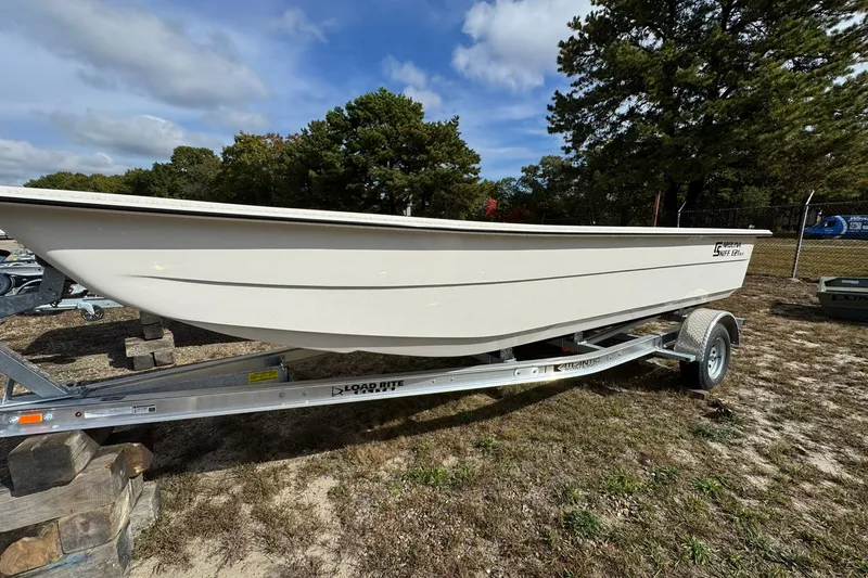Slide: The Image of 2025 Carolina Skiff E21 DLX Kit boat on trailer, parked outdoors. - 9