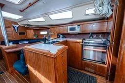 Slide: The Image of 2003 Hunter 356 yacht interior with wooden cabinetry, kitchen appliances, and skylights. - 21