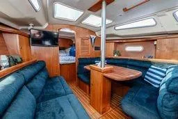 Slide: The Image of Interior of a 2003 Hunter 356 sailboat with blue seating and wooden finishes. - 22