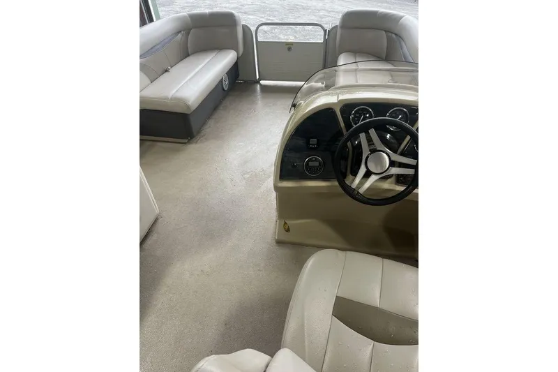 Slide: The Image of Interior of a 2016 Godfrey 2086 boat with steering wheel and seating. - 14