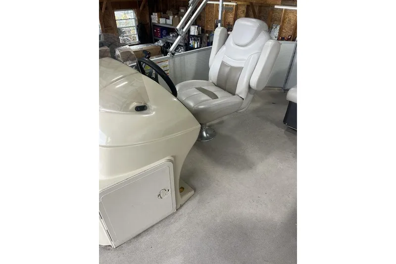 Slide: The Image of Captain's chair and console of 2016 Godfrey 2086 boat in a garage setting. - 20