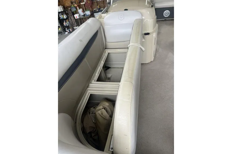 Slide: The Image of 2016 Godfrey 2086 boat interior with open storage compartment and beige seating. - 24