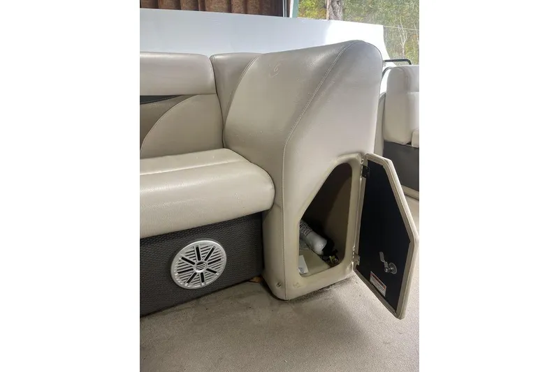 Slide: The Image of Beige boat seating with storage compartment open, featuring a speaker below. Godfrey 2086, 2016 model. - 31
