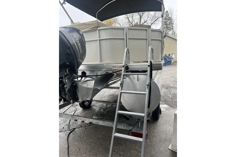 Slide: The Image of 2016 Godfrey 2086 pontoon boat with Yamaha motor and ladder, parked outdoors. - 4